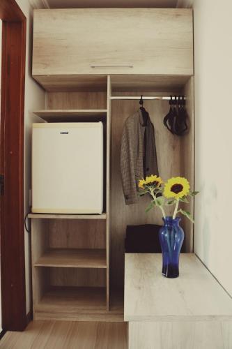 a walk in closet with a vase with flowers in it at Hotel Solaris in São Miguel dʼOeste