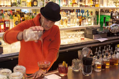 
a man in a chef's hat is pouring a glass of wine at The Standard - East Village in New York
