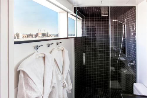 een badkamer met witte handdoeken en een douche bij The Standard - East Village in New York