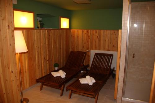 マッサーベルクにあるHotel & Café Daheimの木製の壁の客室に座る木製椅子2脚