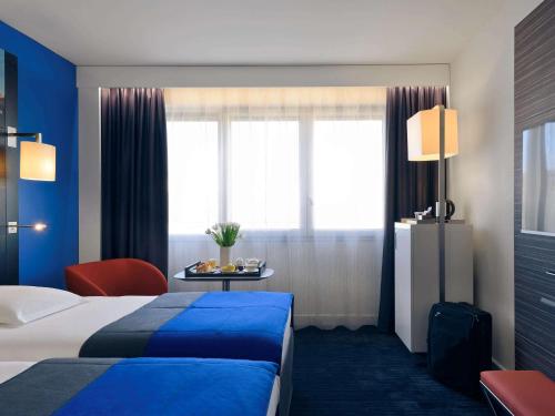 a hotel room with a bed and a table at Mercure Nice Centre Notre Dame in Nice