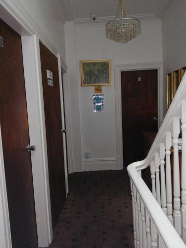 a hallway with stairs and a chandelier at The Garnett in Blackpool