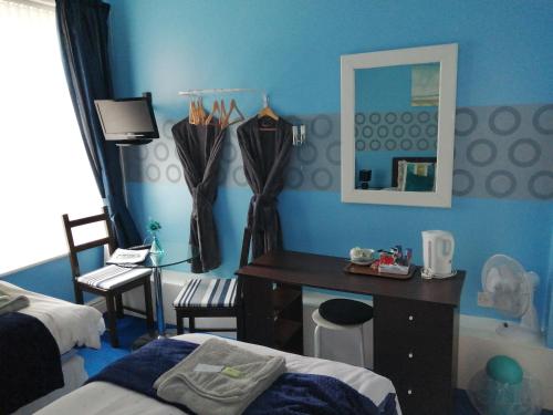 a bedroom with a desk and a bed and a mirror at The Garnett in Blackpool