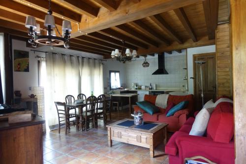 sala de estar con sofá rojo y mesa en llar de Cosme, en Caso