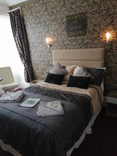 a bedroom with a large bed with some clothes on it at The Garnett in Blackpool
