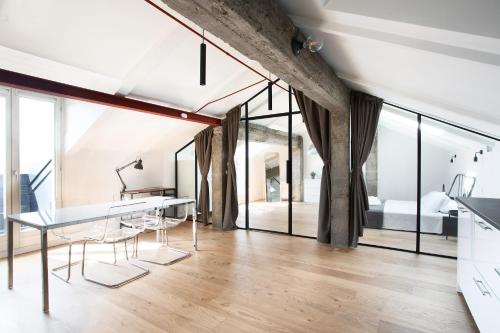 a living room with a table and chairs and a bedroom at Mato Apartment Torino in Turin