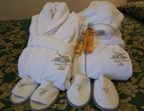 a group of towels and slippers on a bed at Hotel Alle Alpi in Moena