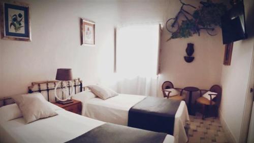 a bedroom with two beds and a window at La Casa De Las Bicicletas in Cazorla