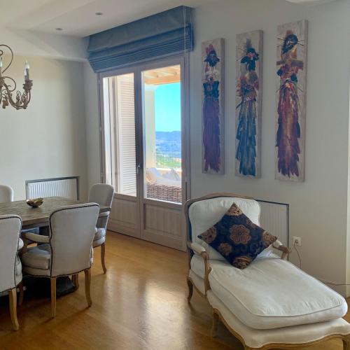 a dining room with a table and a chair and a window at Endless Blue in Anavissos