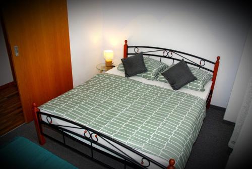 una camera da letto con un letto con un piumone e cuscini verdi di Apartment Erika a Oberasbach