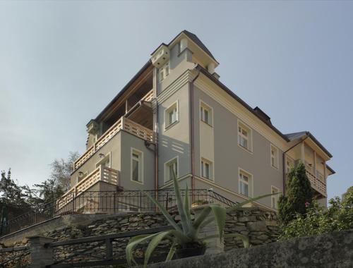 a large building sitting on top of a stone wall at Penzion Vila Elektra in Bechyně