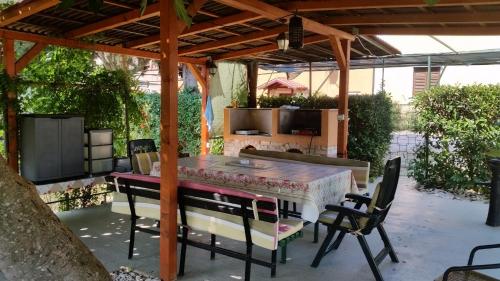 a patio with a table and chairs under a pergola at Apartments Vera Barbariga in Barbariga