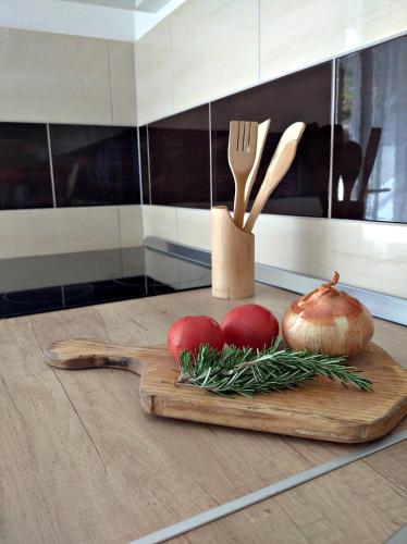 un tagliere con due pomodori, una forchetta e un coltello di Secret Garden a Neum