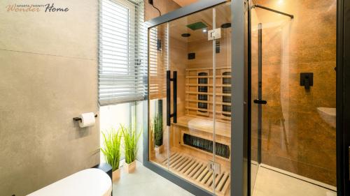 a bathroom with a glass shower and a toilet at Wonder Home - Domki górskie wolnostojące z prywatnymi tarasami - zielona okolica in Karpacz