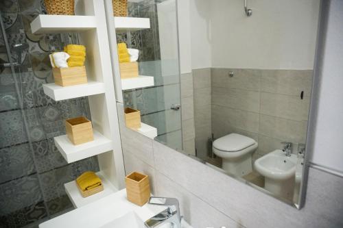 a bathroom with a sink and a toilet and a mirror at S'Ilixi in Quartucciu