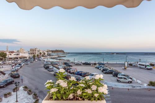 a view of a beach with cars parked in a parking lot at Fratelli Family Rooms in Tinos Town