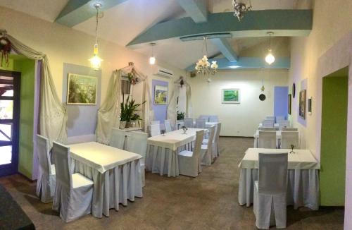 a dining room with white tables and white chairs at Міні-готель "ЕКО" in Kamianets-Podilskyi