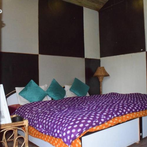 The Sanatan- Bamboo Huts في جوشيماث: غرفة نوم مع سرير ووسائد زرقاء