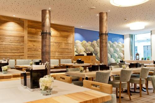 een restaurant met houten muren en tafels en stoelen bij Hotel Zur Post in Ismaning
