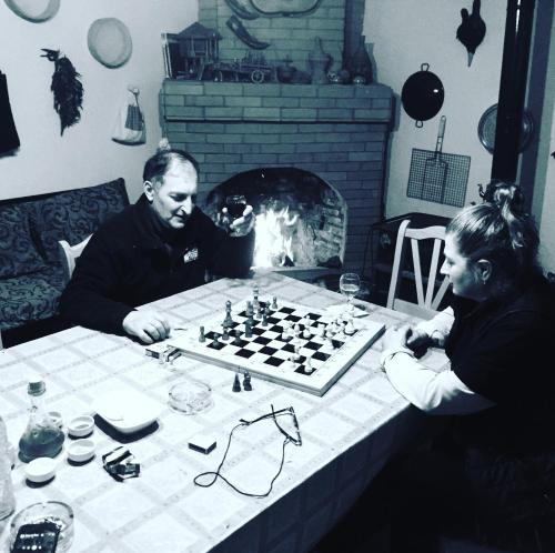 a man and woman playing chess in front of a fireplace at Lazuri Keria Family Guesthouse in Khoni