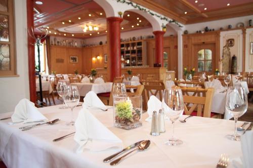 a dining room with tables with white tablecloths at Hotel Zur Post in Ismaning