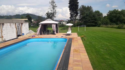 a swimming pool in a yard with a gazebo at Penzion Mirabel in Bešeňová