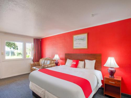 a red bedroom with a large bed with a red wall at Capital O Padre Island Corpus Christi in Corpus Christi