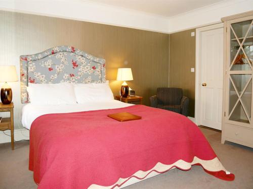 a bedroom with a large bed with a red blanket at The Angel in Wootton Bassett in Royal Wootton Bassett