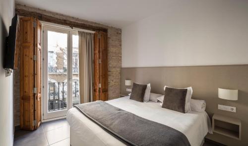 a bedroom with a large bed and a large window at Mon Suites San Martin in Valencia