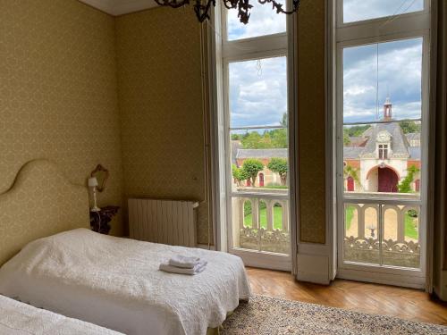 sypialnia z łóżkiem i dużym oknem w obiekcie Château du Maurier w mieście La Fontaine-Saint-Martin