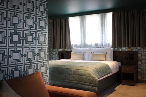 a bedroom with a bed with a large window at The Comet London Hatfield in Hatfield
