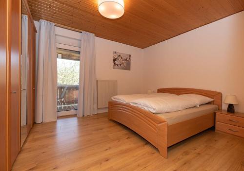 ein Schlafzimmer mit einem Bett und einem großen Fenster in der Unterkunft Ferienwohnung Apfelblüte in Burgbernheim