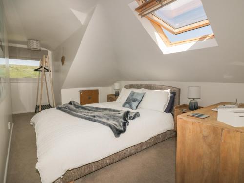 a bedroom with a bed and a skylight at Atlantic View in Newquay