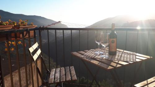 una mesa con una botella de vino y copas en el balcón en Casa Sofia en Levanto