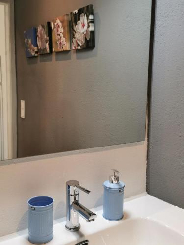 a bathroom sink with a mirror and two cups on it at Estudios Placeta dels Bous - Plaza Constitución in Benicarló