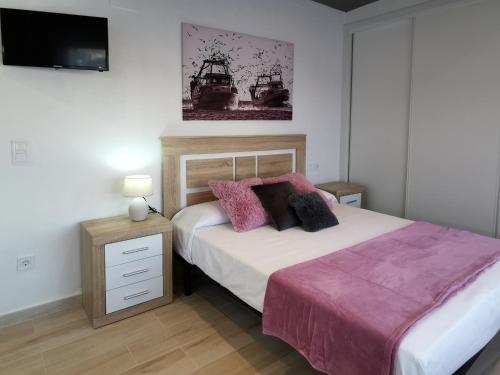 a bedroom with a bed and a tv on the wall at Estudios Placeta dels Bous - Plaza Constitución in Benicarló