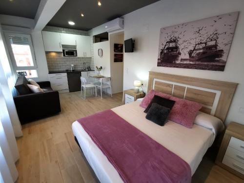 a bedroom with a large bed and a living room at Estudios Placeta dels Bous - Plaza Constitución in Benicarló