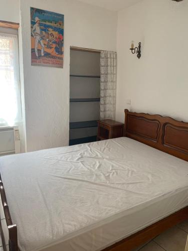 een slaapkamer met een groot bed met witte lakens bij SAINT ANTOINE in Marcoux