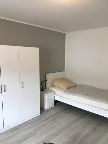 um quarto com uma cama e um armário branco em Gemütliches Ferienzimmer Hürth em Hürth