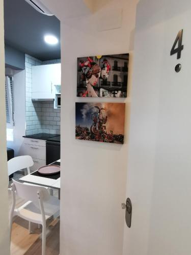 a kitchen with a white door with pictures on the wall at Estudios Placeta dels Bous - Plaza Constitución in Benicarló