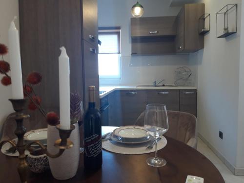 a dining room table with a bottle of wine and glasses at Apartmani Ponistra in Šibenik