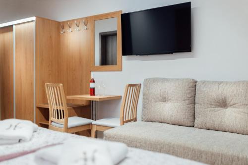 a living room with a couch and a table with chairs at Penzion U Harmáčků in Hustopeče