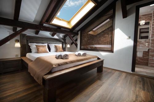 a bedroom with a large bed with two towels on it at Hotel Antique - free private parking in Plovdiv