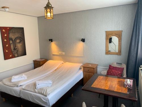 ハーレムにあるアマデウス ホテルのベッドとテーブルが備わるホテルルームです。