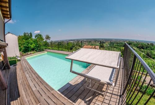 a pool with a table and a chair on a deck at Agriturismo Dai Gobbi in Fara Vicentino
