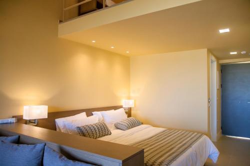 a bedroom with a bed with two lamps on it at Ilion Beach Hotel in Gerani Chanion
