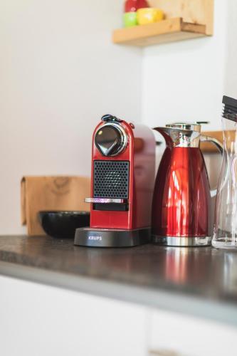 a red phone sitting on a counter next to a blender at Löwen Chalets in Seefeld in Tirol