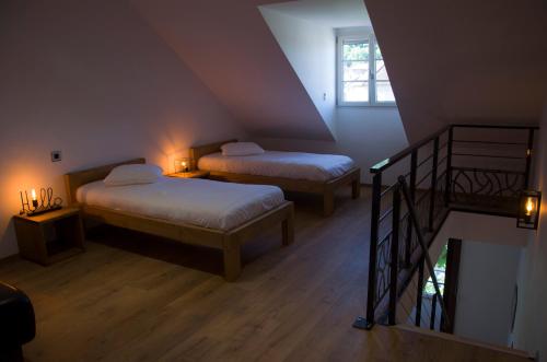 Cette chambre mansardée comprend deux lits et un escalier. dans l'établissement Aux Platanes, à Poligny