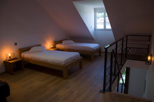 a attic room with two beds and a staircase at Aux Platanes in Poligny