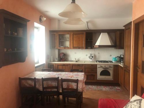 kuchnia ze stołem, krzesłami i kuchenką w obiekcie Casa Rosa w mieście Dervio